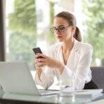 serious businesswoman using smartphone in workplace